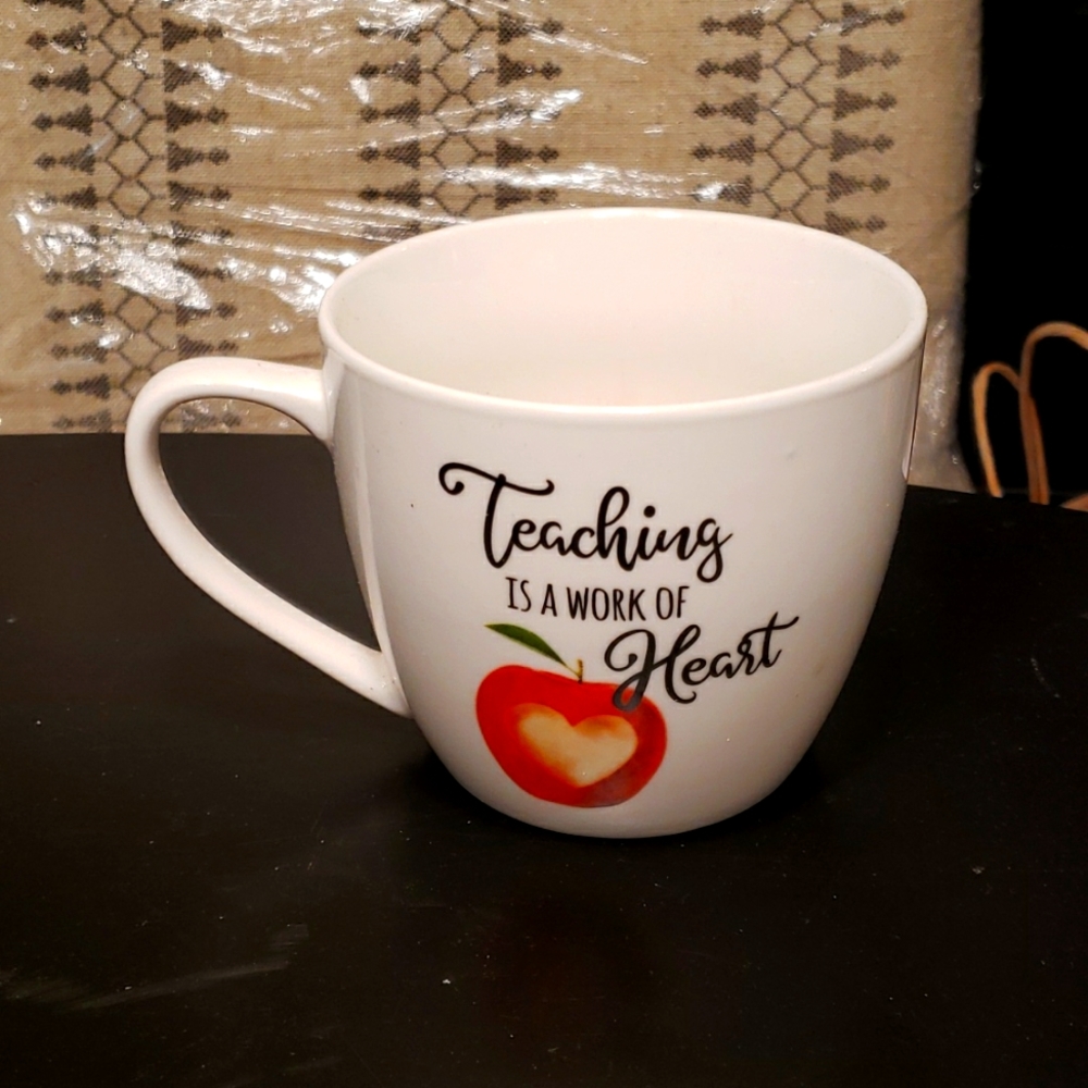 Teacher's mug. White with black writing and an apple emblem